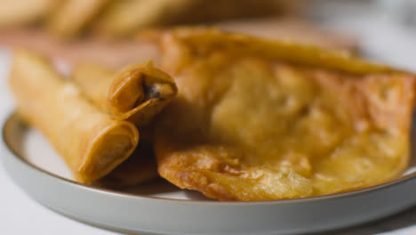 Close-Up-Of-Plate-Of-Samosas-And-Glass-Of-Water-On-Marble-Surface-Celebrating-Muslim-Festival-Of-Eid-1